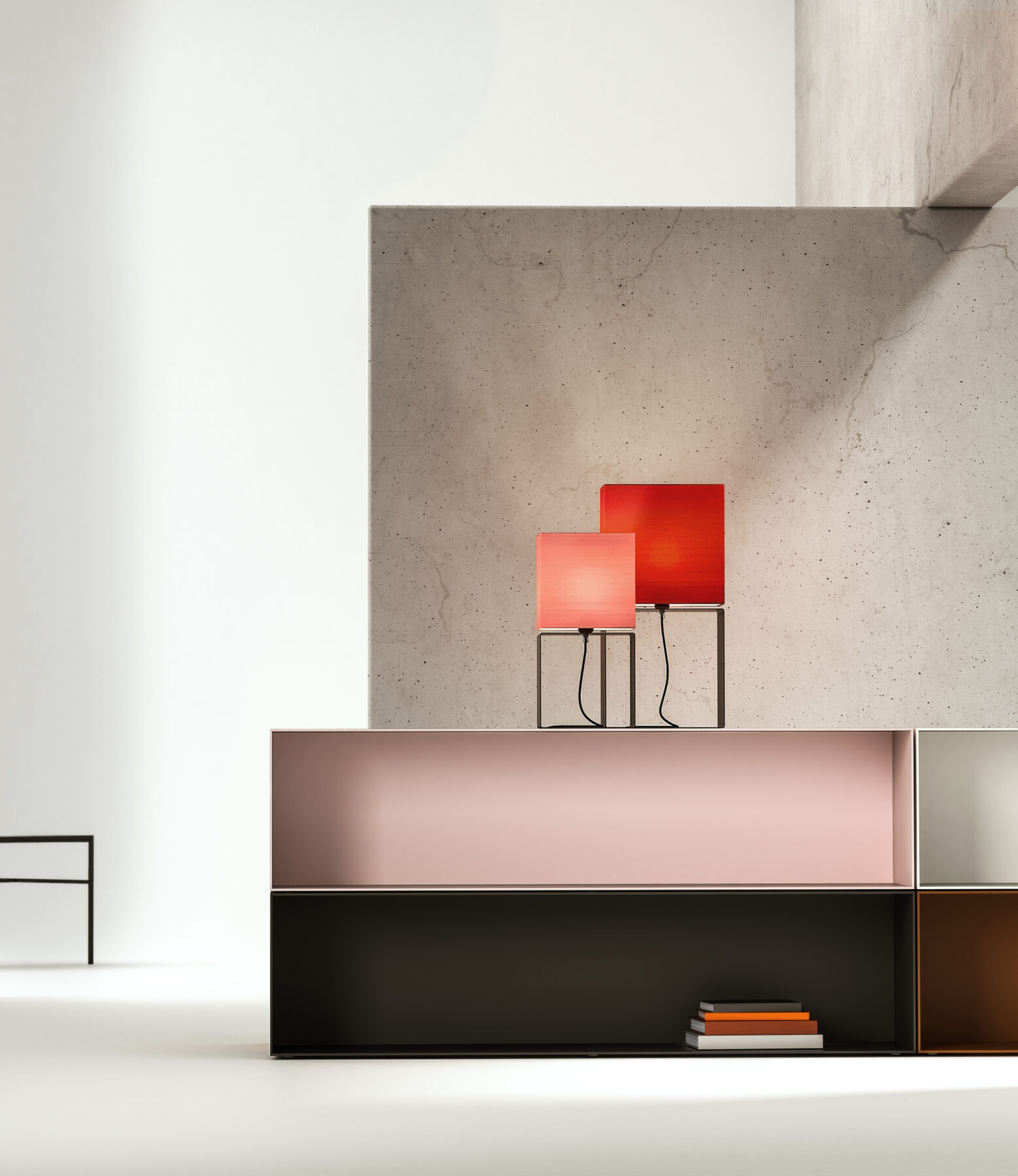 Two sizes of the CUBIC GATE table lamp in pink and red on a sideboard in a modern studio.