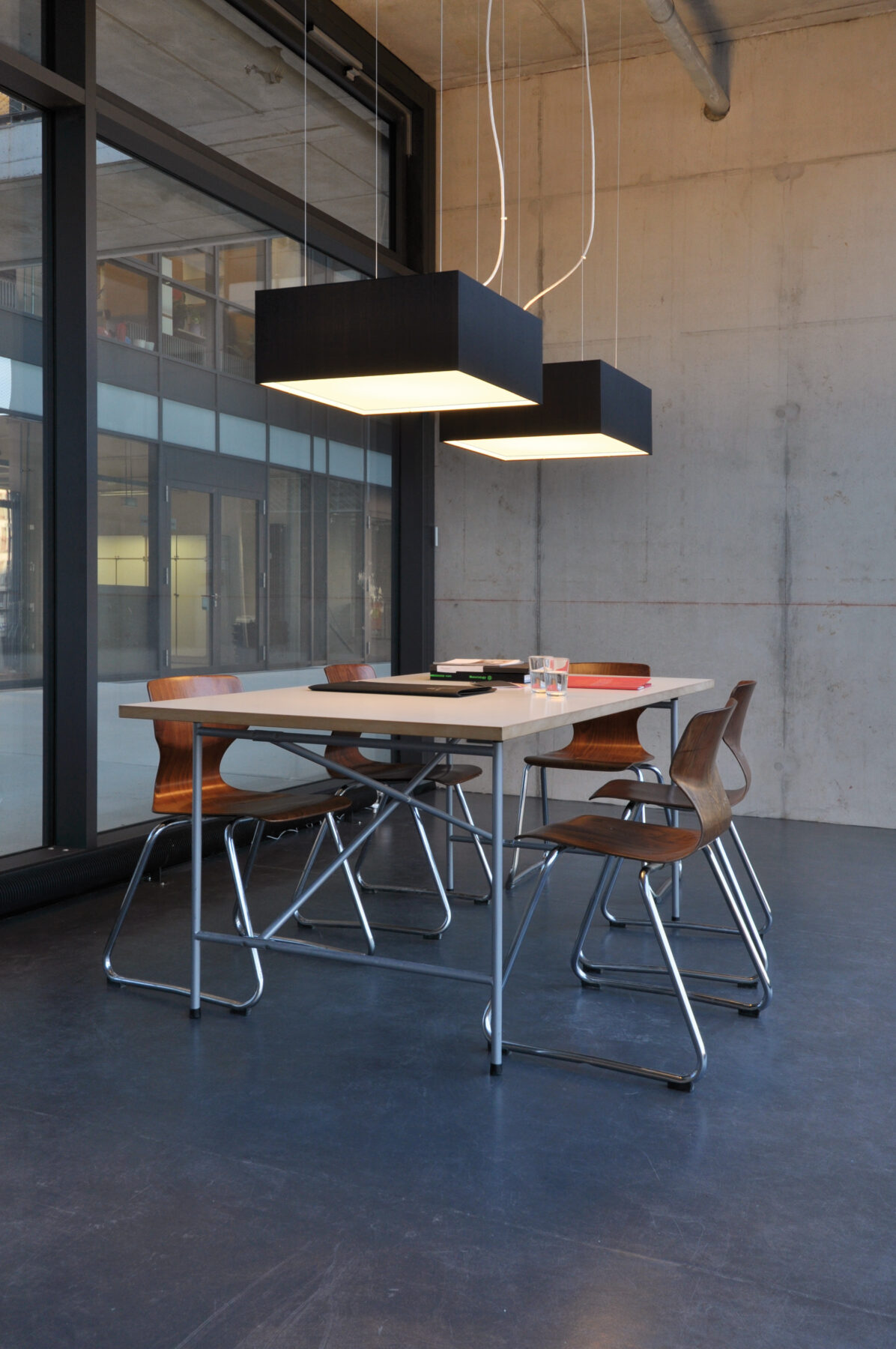 CUBIC FRAME pendant lights in black silk above a table a the creative studio.