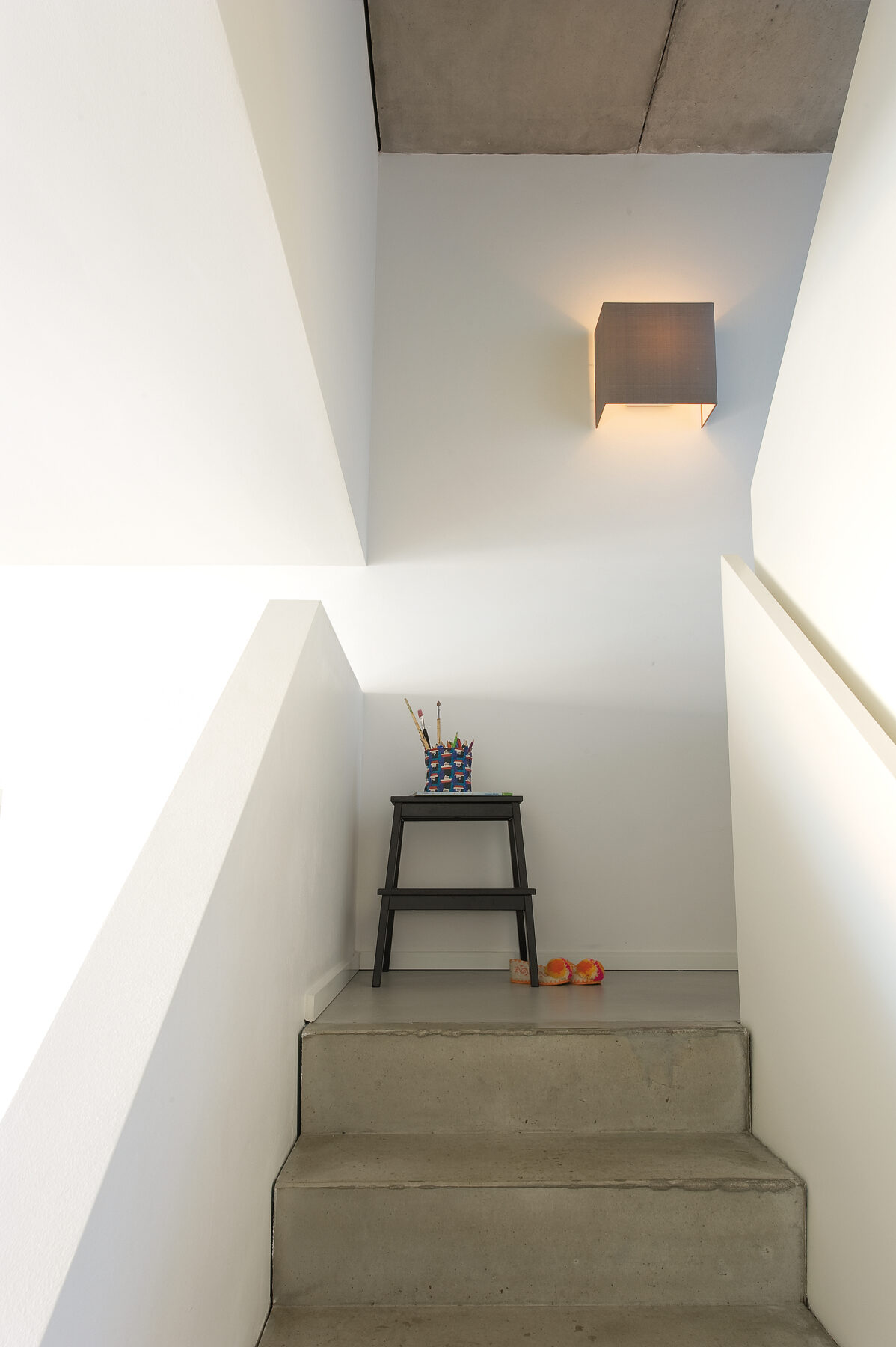 CUBIC BOX wall lamp in an open staircase of a bright flat.