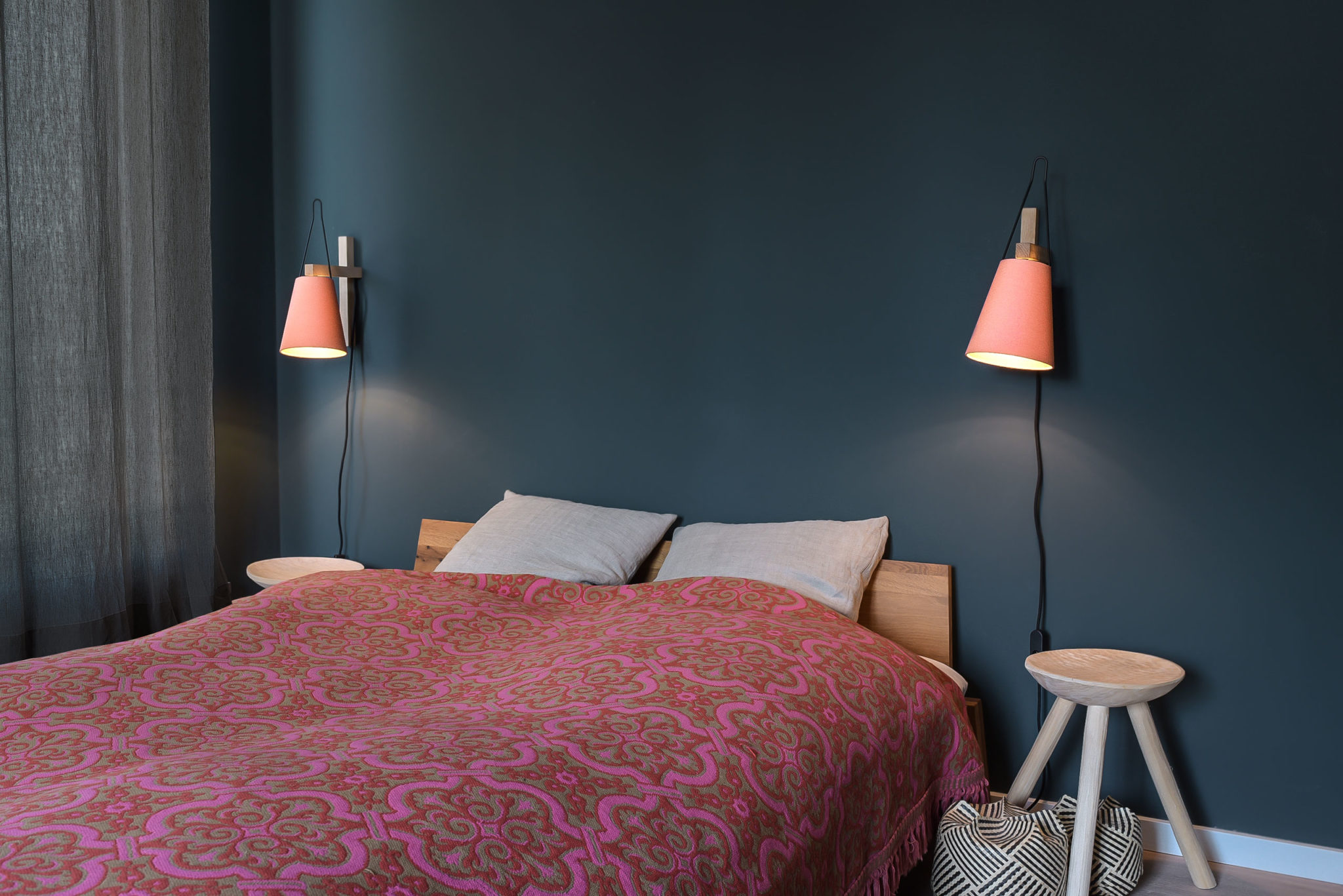 A pair of MINA wall lamps in Chintz Flamingo next to the bed.