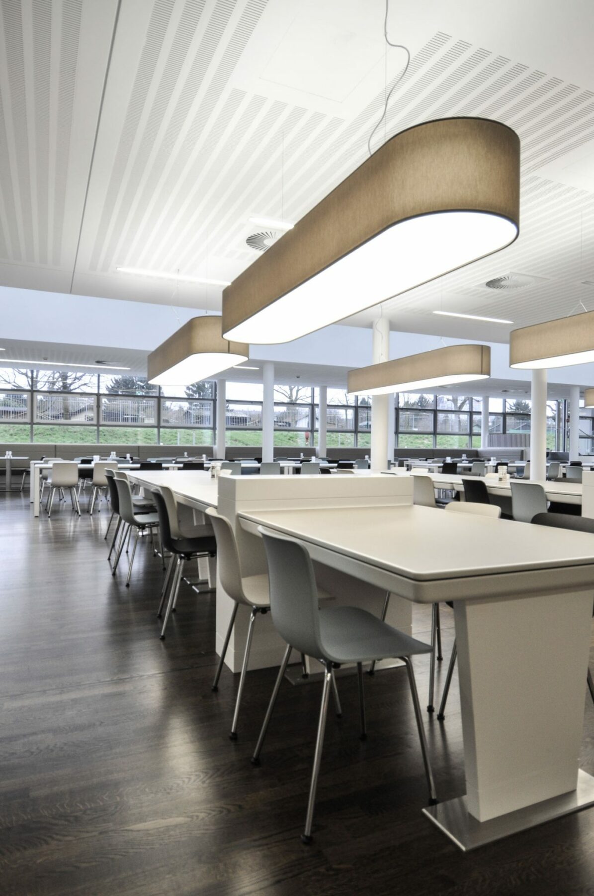 Extra long textile shade lights in grey chintz in the canteen of the Lateral Towers.