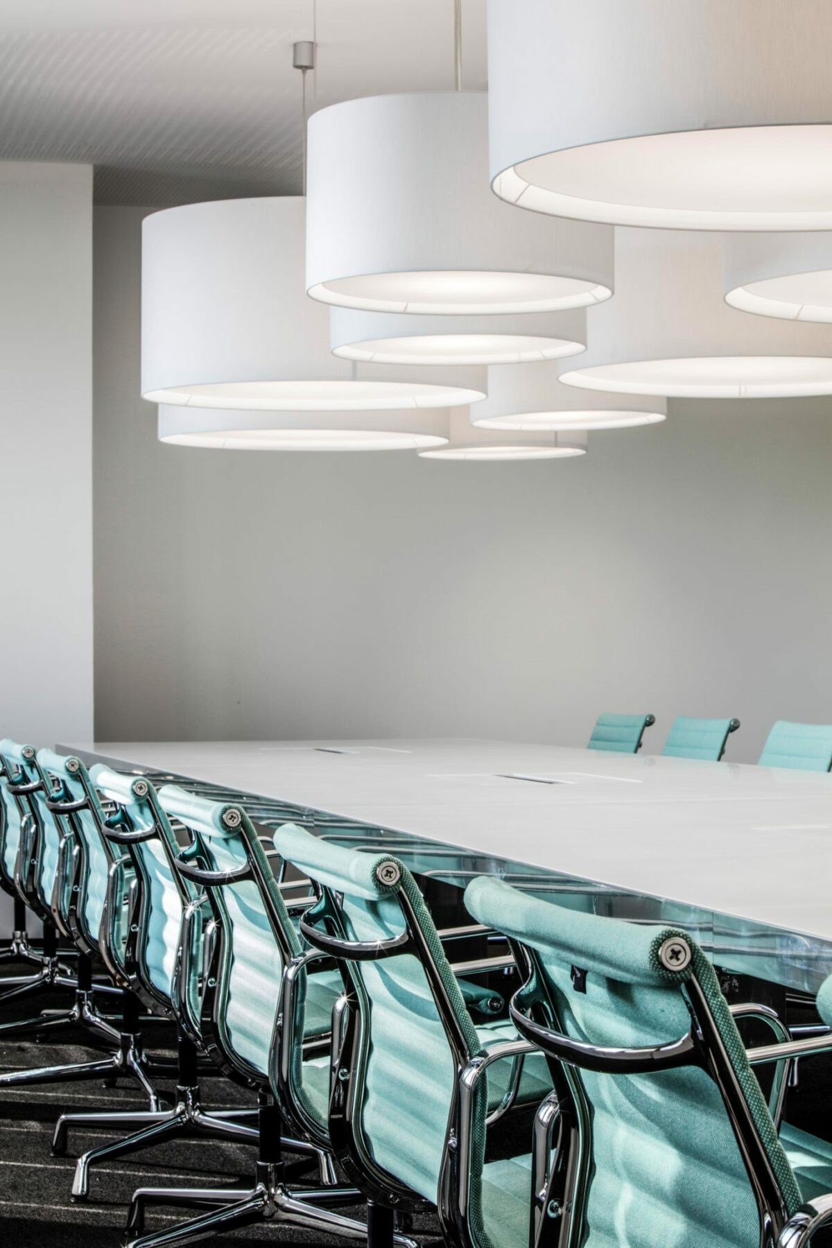 Group of white CYLS DRUM pendant lamps in a modern conference room.