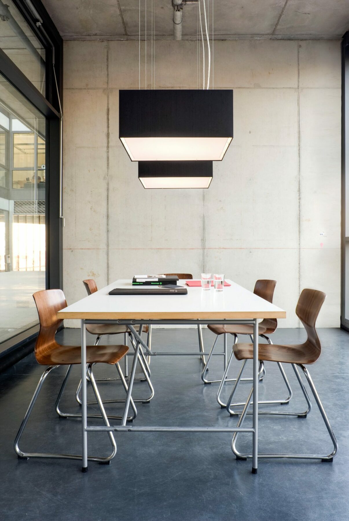 CUBIC FRAME pendant lights in black silk above a table in the creative studio.